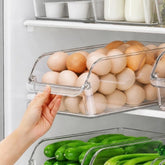 Clear plexi fridge organizer bins holding eggs and cucumbers inside a refrigerator