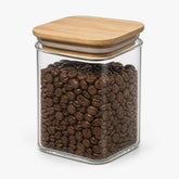 Square glass storage jar with bamboo lid filled with coffee beans