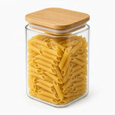 Square glass storage jar with bamboo lid filled with penne pasta