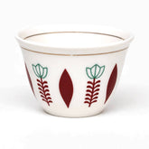 Close-up of a white Arabic coffee cup with turquoise tulip and burgundy leaf pattern and gold rim lines