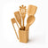 5 bamboo cooking utensils standing in a square bamboo holder