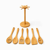 Empty bamboo utensil stand with 6 pegs and 6 bamboo spoons, turners and spaghetti server laid in front