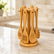 Bamboo utensil carousel stand with 6 hanging utensils on a marble kitchen counter