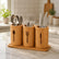 Bamboo utensil organizer holding spoons, forks and knives on a marble kitchen counter