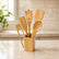 Bamboo utensils in a holder on a marble kitchen counter