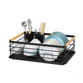 Black metal dish rack with bamboo handles holding plates, bowls, glasses and utensils