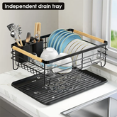 Black dish rack lifted off its separate drip tray by a kitchen sink