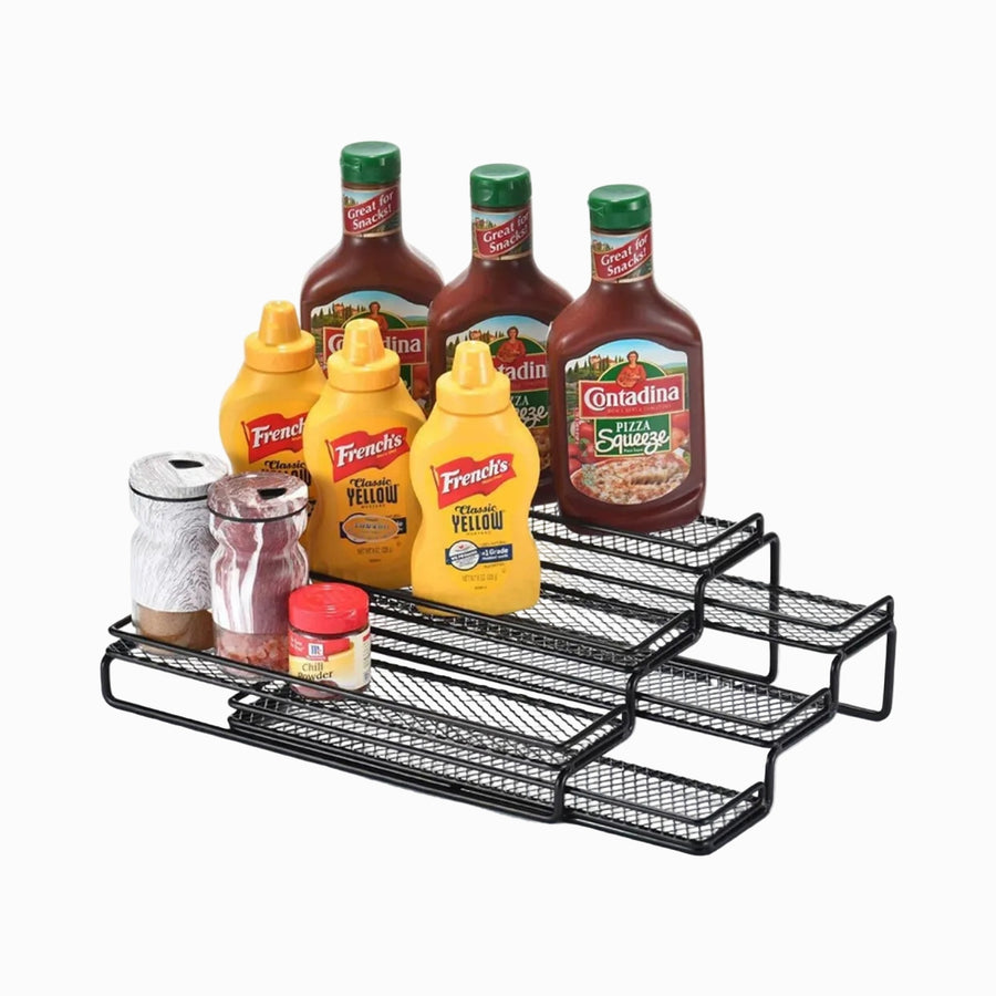 Black metal expandable 3-tier spice rack holding sauce bottles and spice jars