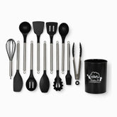 11 black silicone cooking utensils with stainless steel handles laid flat next to their black utensil holder