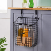 Black wire basket hanging on a grey cabinet door holding bottles and a kraft box