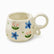 Cream ceramic mug with painted blue flowers, pink tulips and a looped ring handle