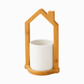 White ceramic utensil cup in a house-shaped bamboo frame