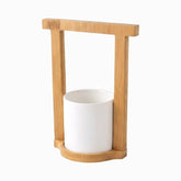 White ceramic utensil cup in a square bamboo frame