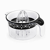 Black plexi citrus juicer with clear ribbed reamer, white bowl and black patterned band on a 400ml measuring jug