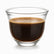 Single clear glass Arabic coffee cup filled with dark Lebanese coffee and a foam layer on top