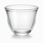 Close-up of a clear glass Arabic coffee cup with flared rim and thick base