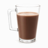 Single clear glass mug with square handle filled with hot chocolate and light foam