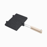 Black granite double-sided grill pan with wooden handles, closed