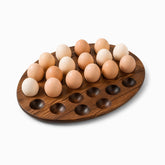 Egg-shaped acacia wood egg tray with 24 holes, partly filled with brown and cream eggs