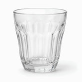Close-up of a clear flared paneled tea glass with long panels and multi-sided base