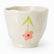 Cream handleless ceramic cup with wavy rim and a painted pink flower with long green leaves