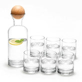 Clear glass carafe with wooden ball stopper and 6 tumblers with water, lemon and ice