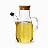 Glass oil dispenser with bamboo lid, capped spout and measurement marks to 500ml, filled with olive oil