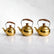 Gold stainless steel teapots in 3 sizes on a marble counter