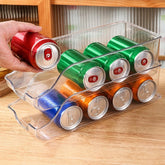 Hand taking a red can from two stacked clear can organizers on a wooden counter
