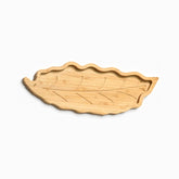 Empty leaf-shaped bamboo serving tray with wavy rim and carved vein grooves