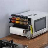 Magnetic rack on the side of a microwave with spice jars, paper towels and hanging tools