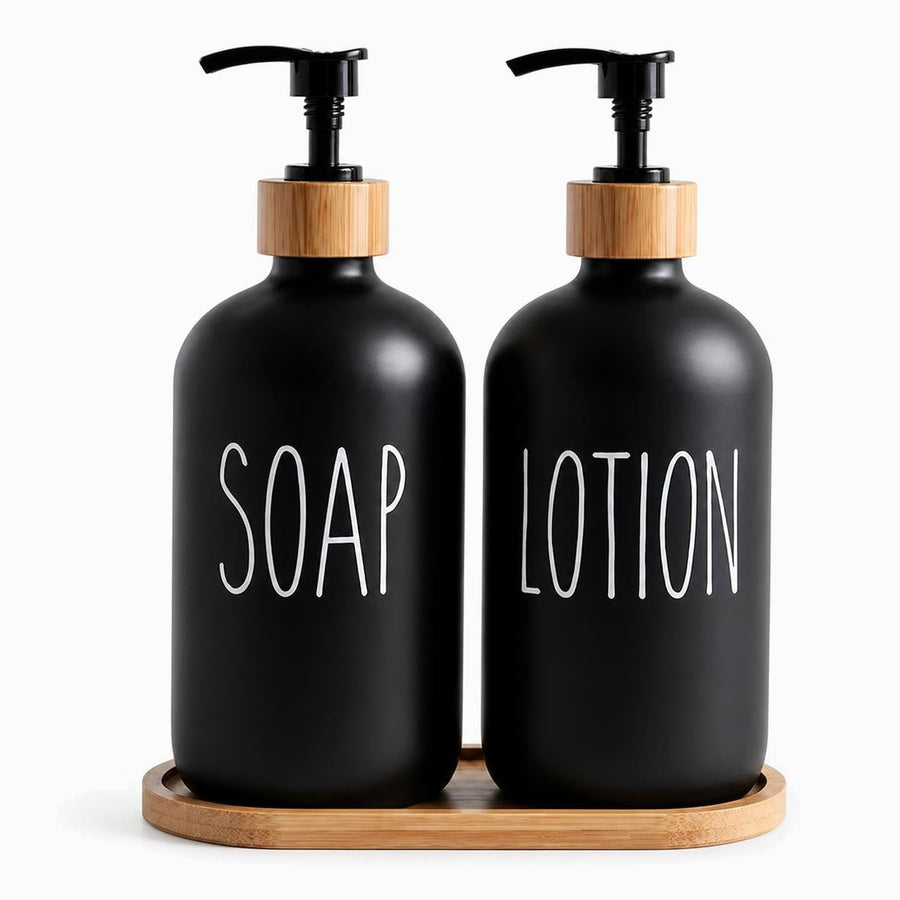 Matte black soap and lotion pump bottles with bamboo collars standing on an oval bamboo tray