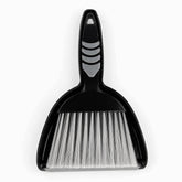 Black mini dustpan with nested hand brush, grey rubber grip pads and silver-white bristles, top view