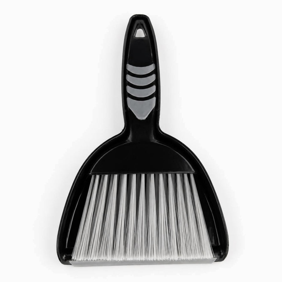 Black mini dustpan with nested hand brush, grey rubber grip pads and silver-white bristles, top view