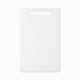 White plastic cutting board with handle slot and rounded corners, top view