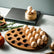 Oval wooden egg tray half filled with eggs on a marble counter with rosemary