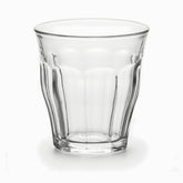 Close-up of a clear paneled tea glass with smooth top band and thick faceted base