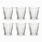 Set of 6 clear paneled tea glasses with faceted base arranged in 2 rows