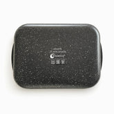 Bottom of a black granite baking pan with Phoenix stamp and electric, ceramic and gas icons