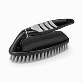 Black plastic scrub brush with grey rubber grip pads, arched handle and silver-grey bristles