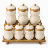 7 cream textured porcelain canisters with bamboo bands and knobs on a 2-tier bamboo rack, 3 tall and 4 short
