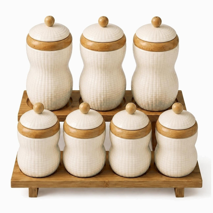 7 cream textured porcelain canisters with bamboo bands and knobs on a 2-tier bamboo rack, 3 tall and 4 short