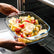 Glass baking dish with potatoes, cherry tomatoes and rosemary going into the oven