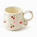 Cream ceramic mug with painted red cherries, tiny red dots and a looped ring handle