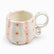Cream ceramic mug with soft pink stripes, red dots and small pink flowers