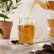 Tea poured into a ribbed glass tea cup with saucer, served with cardamom and star anise