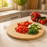 Round bamboo cutting board with chopped tomatoes, cucumber and parsley on a kitchen counter