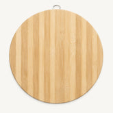 Top view of a round bamboo cutting board with striped bamboo grain and hanging ring