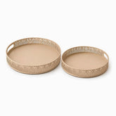Two round beige metal trays in 2 sizes with arch cut-out rims and a handle slot
