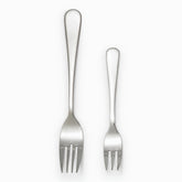 Mirror-polished stainless steel dinner fork and smaller dessert fork side by side
